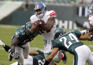 Giants running back Bradshaw is tackled after a gain by the Eagles Asomugha and Fokou during the third quarter of NFL football action in Philadelphia