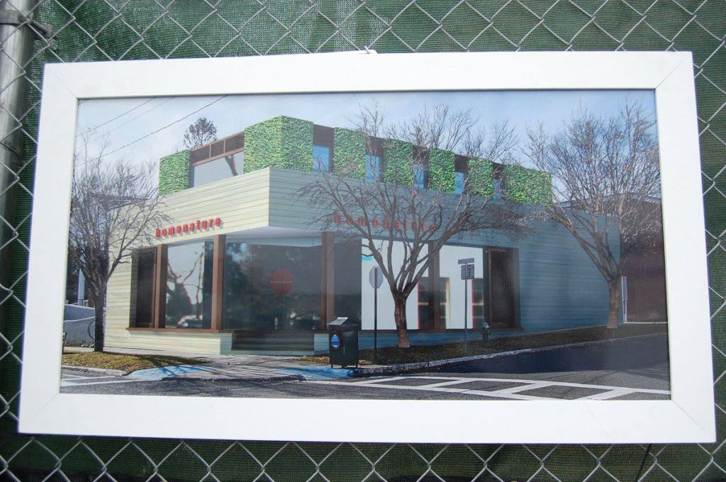 An artistic rendering of what the building will look like once it is complete hangs on a fence at the worksite.