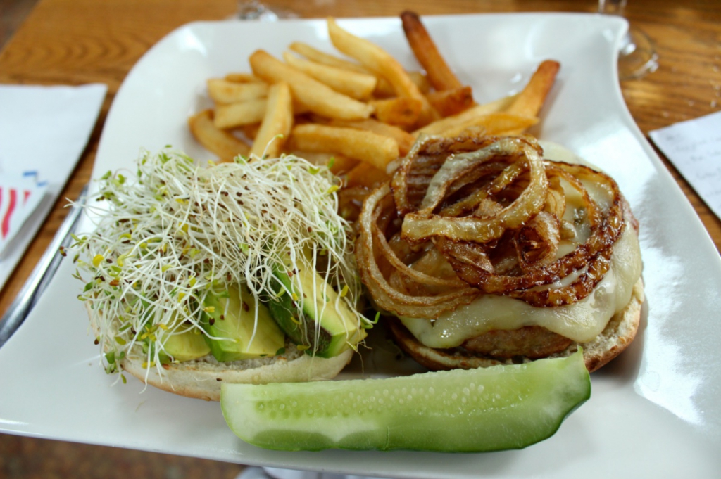A burger with cheese, grilled onions, avocado and sprouts at The Driver's Seat Restaurant in Southampton Village
