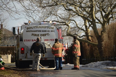 Firefighters fill a tanker truck with water to bring it to West End Avenue, where a mansion burned.