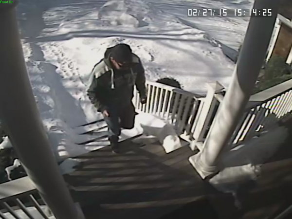 The suspect walks up to the front door.