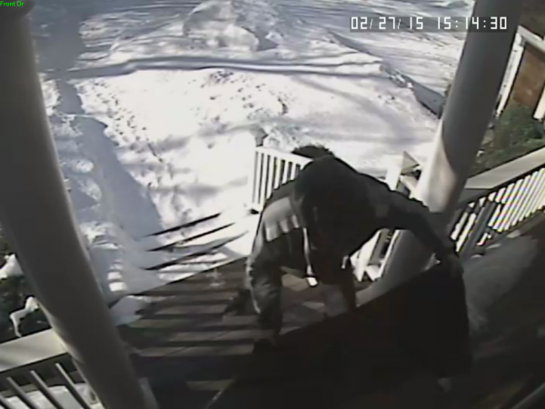 Police say the suspect appears to be checking under the doormat for a key.