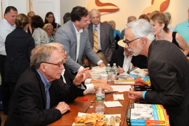 Dick Cavett autographs his book at the meet and greet