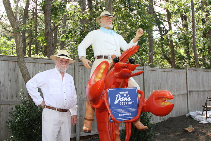 Dan Rattiner standing with the new "Welcome to Dan's Country" statue