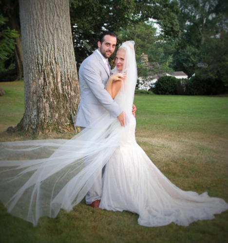 A young couple posing under a tree