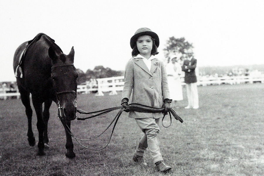 A young Jackie Bouvier leading her Pony