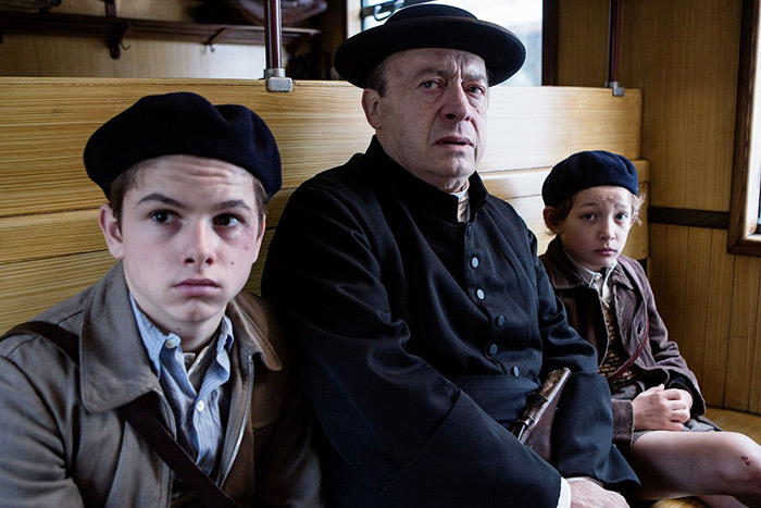 Alone on a train, Jojo and Maurice are protected by a compassionate priest. 