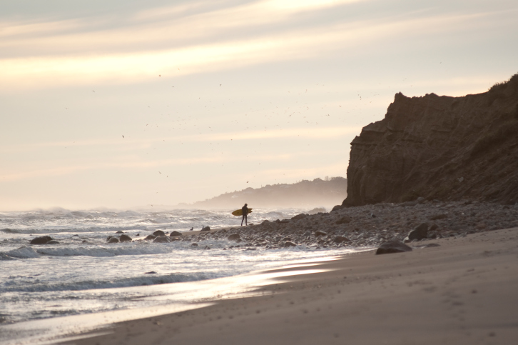 Surfer along coastline, The Hamptons, New York