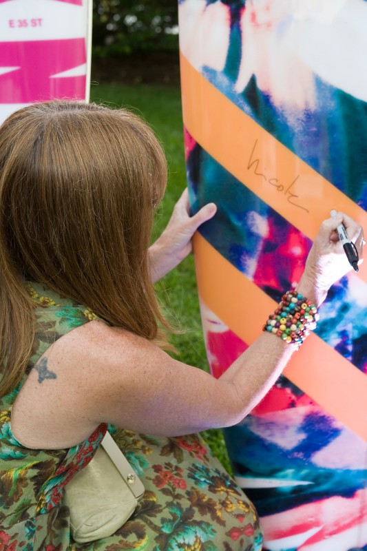 Nicole Miller signing the paddleboard she designed.