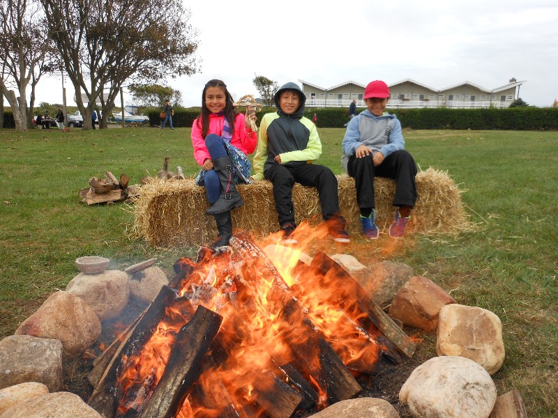 Delilah Desmond, Jhorjan Tacuri and Tom Desmond keeping warm by the fire.
