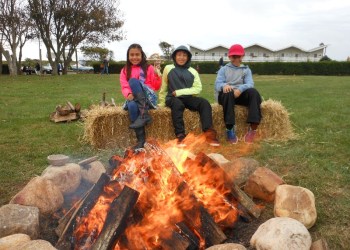 Delilah Desmond, Jhorjan Tacuri and Tom Desmond keeping warm by the fire.

