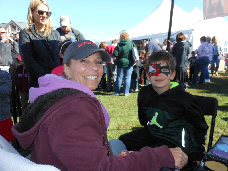 Jonathan Ehlers getting his face painted on by artist April Keough