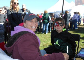 Jonathan Ehlers getting his face painted on by artist April Keough