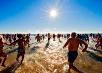 And there they go, splashing and shouting, as they plunged, en masse, into the icy December waters at Coopers Beach for this year's Polar Bear Plunge.