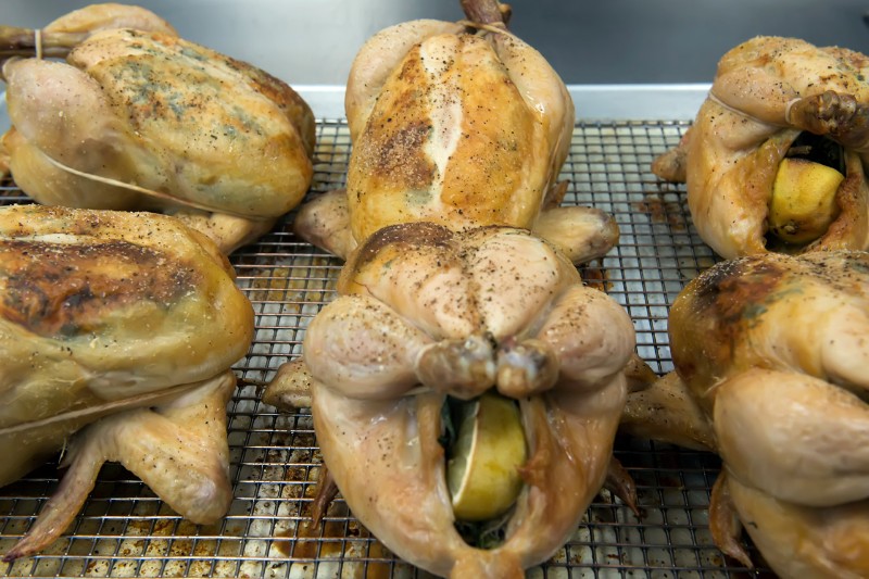 The roasted chicken after reaching the internal temperature are removed from the oven and let to stand