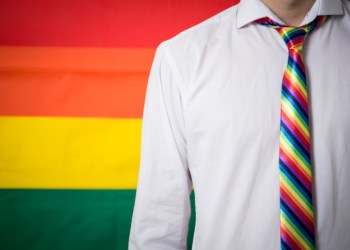 Man wearing shirt and rainbow tie