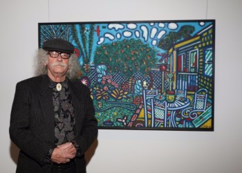 Artist David Slater stands by one of his many bold and energized paintings during the opening of his solo show entitled 