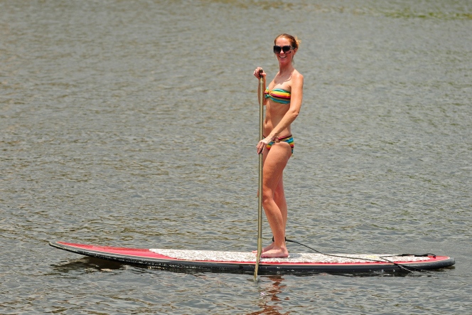 Woman getting exercise by paddleboarding
