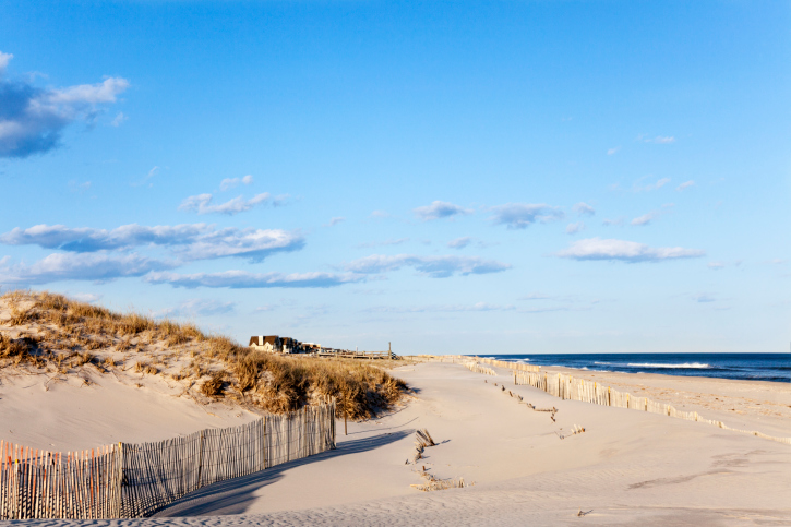 Beach Fence, Sand, Houses and the Ocean.