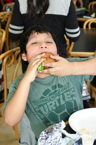 Eustorgio, age 10, takes a bite out of the delicious fish burger
