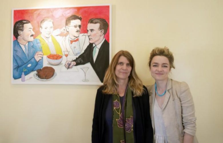 Cathy Suter with her daughter, current artist at Estia's Little Kitchen, Valerie Suter next her one of her paintings, titled The Moveable Feast.