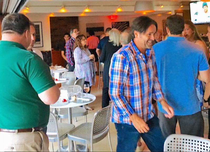 Jim Rooney, (center of photo); principal of FLEXdevelopment/Broker KP Property Group Inc. greets his guests with a big smile and a casual "meet and greet" held  at Cittanuova in East Hampton.