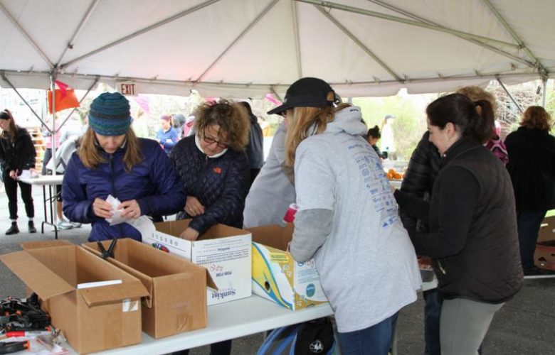 Volunteers distribute bib numbers to each participant
