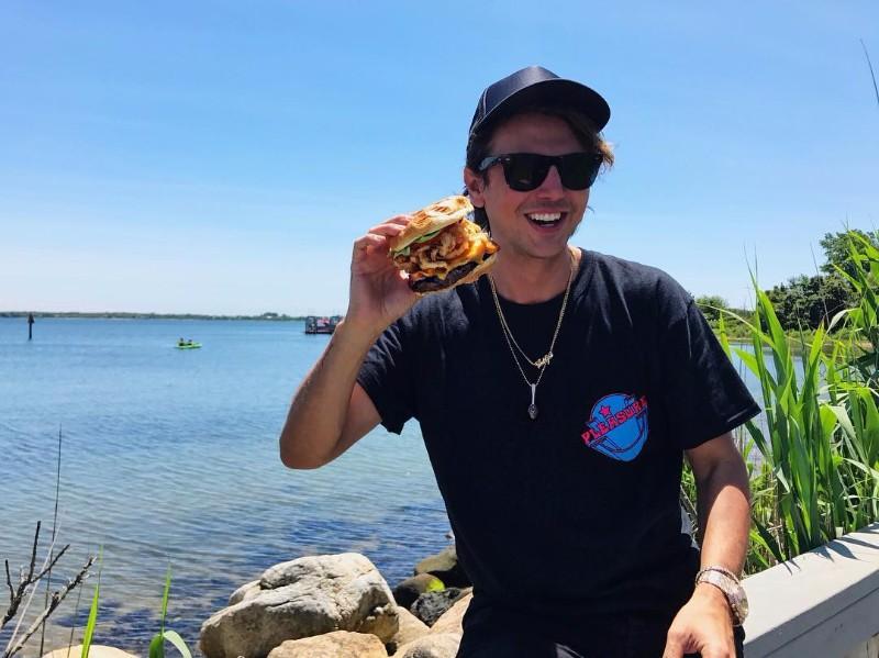 Jonathan Cheban the Foodgod himself at Montauk Yacht Club ​eating their signature burger from Coast Kitchen 