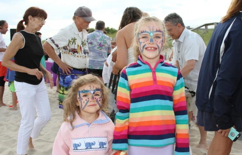 Evelyn, age 3, and Vanessa, age 7, with their colorful painted faces