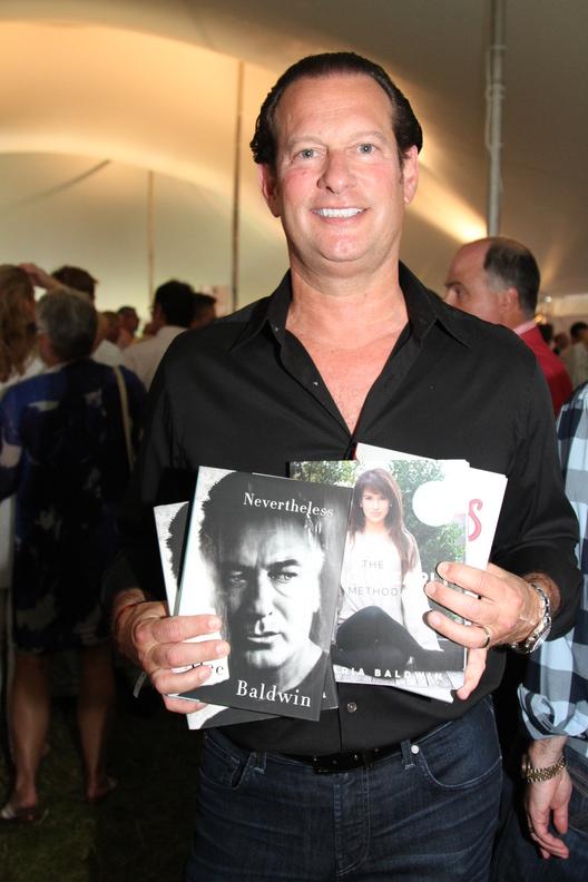 Actor Mark Axelowitz holds up Alec Baldwin's "Nevertheless" and Hilaria Baldwin's "The Living Clearly Method"