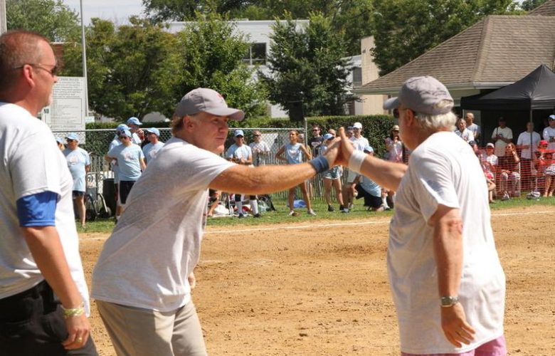 Ed Hollander receives a high five from a teammate for a solid hit to first base