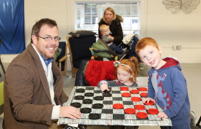 Patrick Harvey plays checkers with Clara age 3 and Liam age 4
