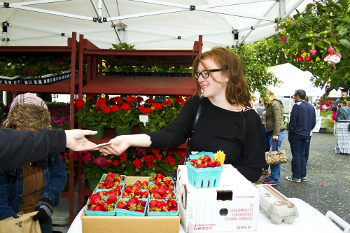 Cameron Curtis, of Manhattan, buys fresh strawberries from Rosa Chavez at the Catapano farm stand.