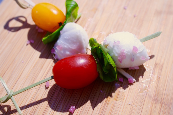 Skewer of mozzarella, cherry tomatoes, and green basil, seasoned with Amagansett Sea Sal