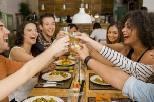 group of friends toasting and looking happy at a restaurant