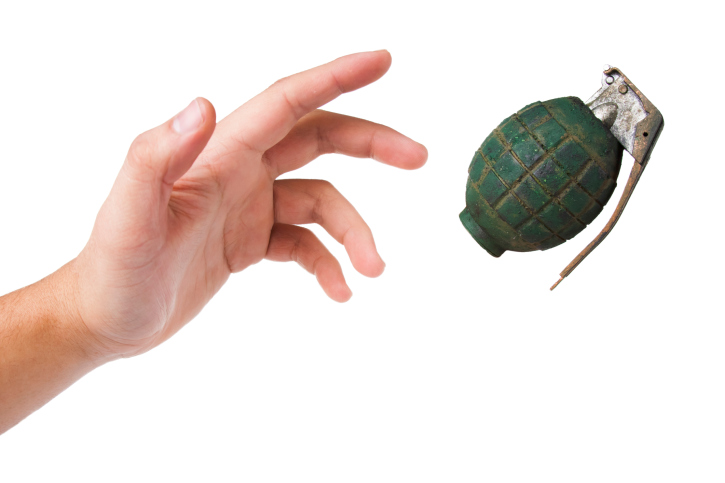 hand throwing a green grenade on white