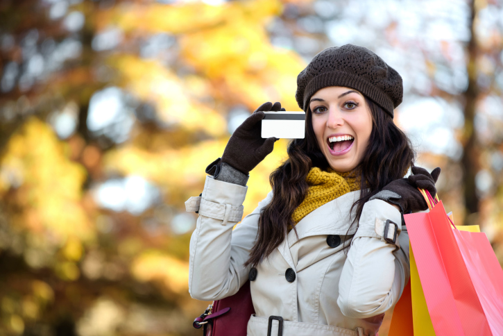 Woman with credit card and shopping bags in autumn