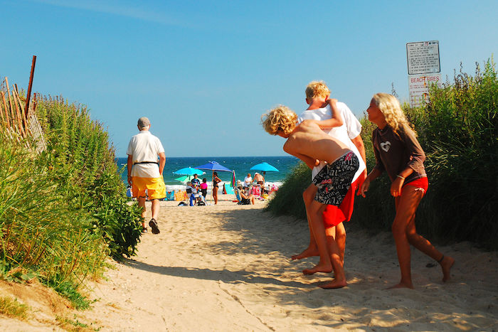 People walking up the sandy path to Ditch Plains beach in Montauk