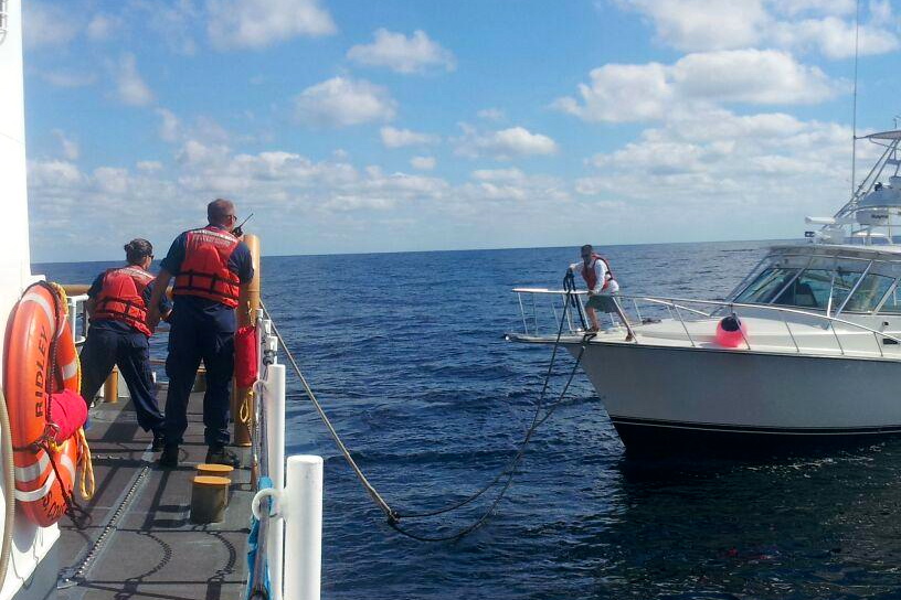 The U.S. Coast Guard tows a pleasure boat that was adrift in the ocean.
