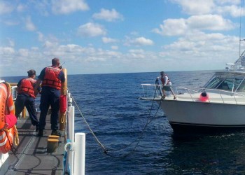 The U.S. Coast Guard tows a pleasure boat that was adrift in the ocean.