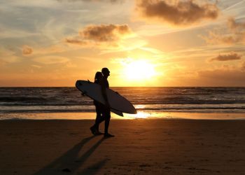 surfers at sunset