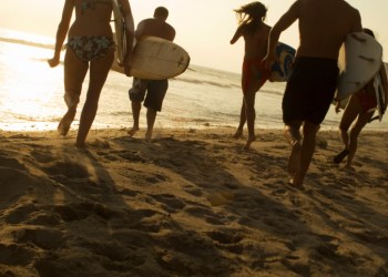Group of Surfers Walking on Beach