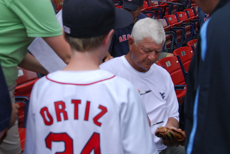 Carl Yastrzemski signs an autograph for a fan at Fenway Park in 2008.