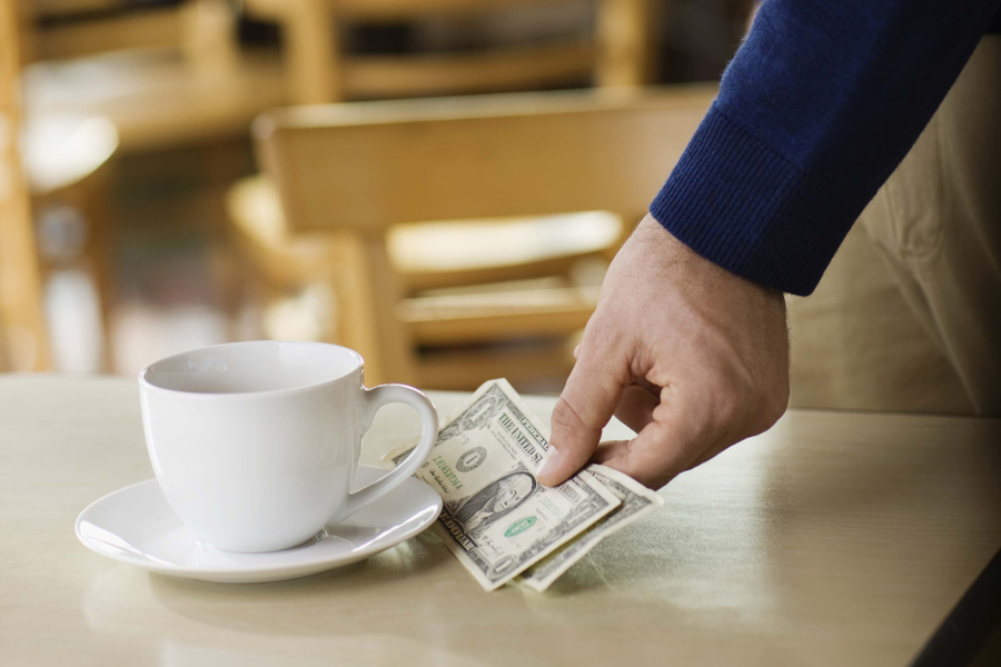 Man leaving tip on table at cafe