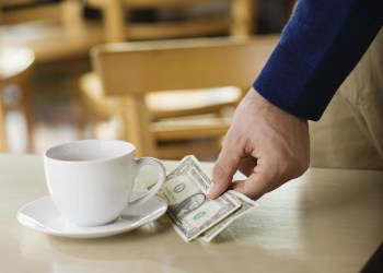 Man leaving tip on table at cafe