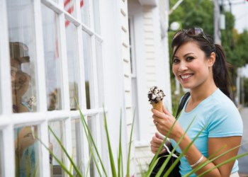 Woman holding an ice-cream cone and smiling