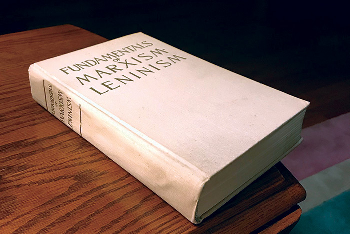 An old hardbound copy of Communist book "Fundamentals of Marxism-Leninism: Manual" on a table