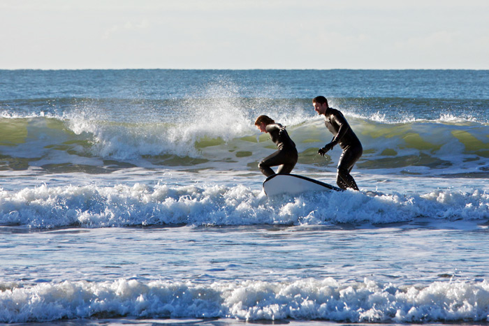 Couple surfing small waves