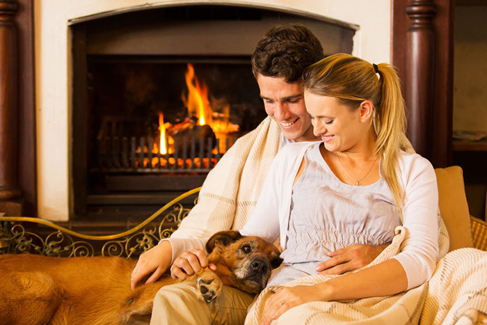 Couple with dog by fire
