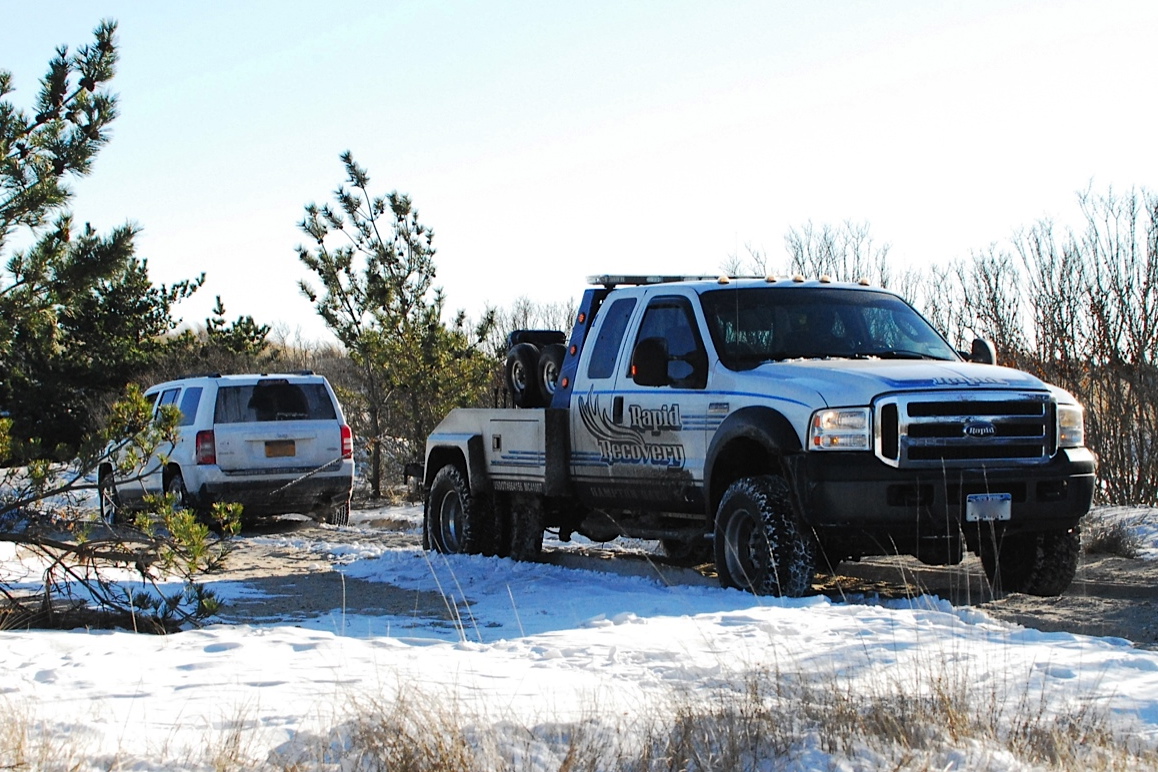 A stuck Jeep SUV is pulled out of a rut on Road G.